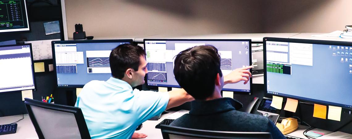 Two men sitting in front of computer monitors