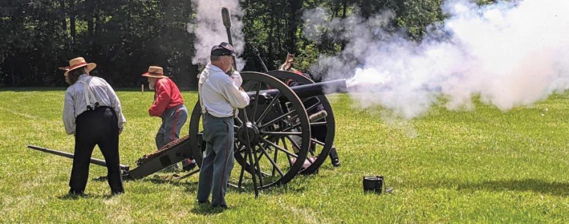 People shooting a cannon during the Encampment at the Confluence event in Defiance, Ohio